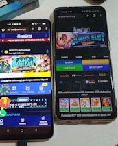 Two smartphones are displayed on a white surface, both showing gambling websites with colorful graphics, text, and various options for logging in and accessing games. The screens are bright and filled with promotional content related to casino and slot games.